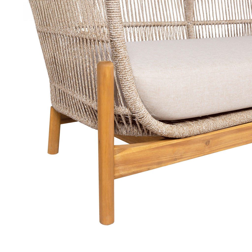 Wicker chair with wooden legs and white cushion on a white background
