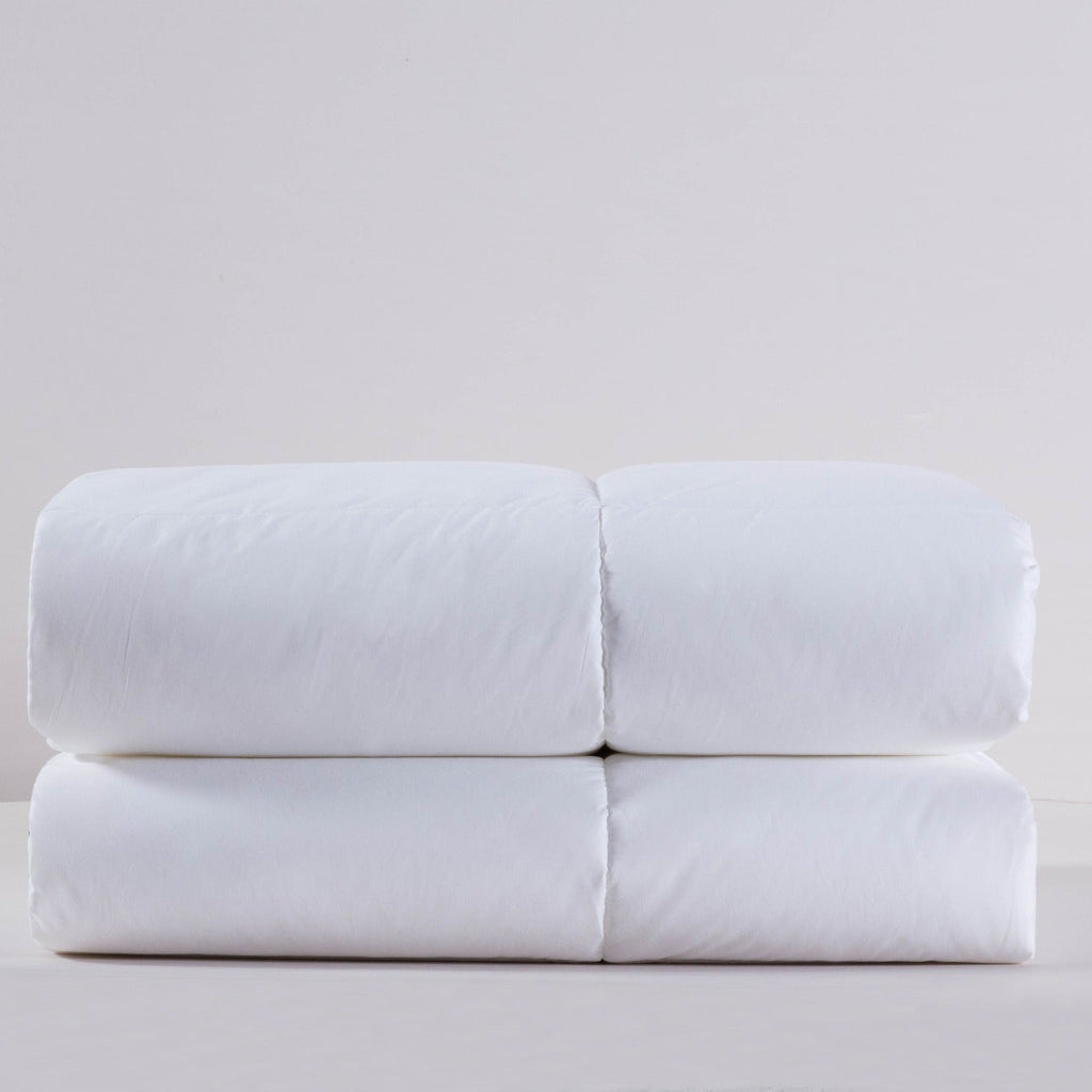 Folded white bed sheets on a light gray background
