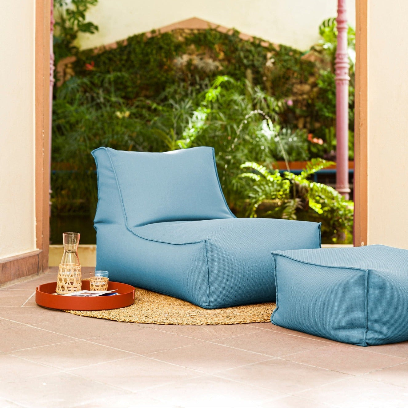 Blue bean bag chair in a room with a large window view of greenery