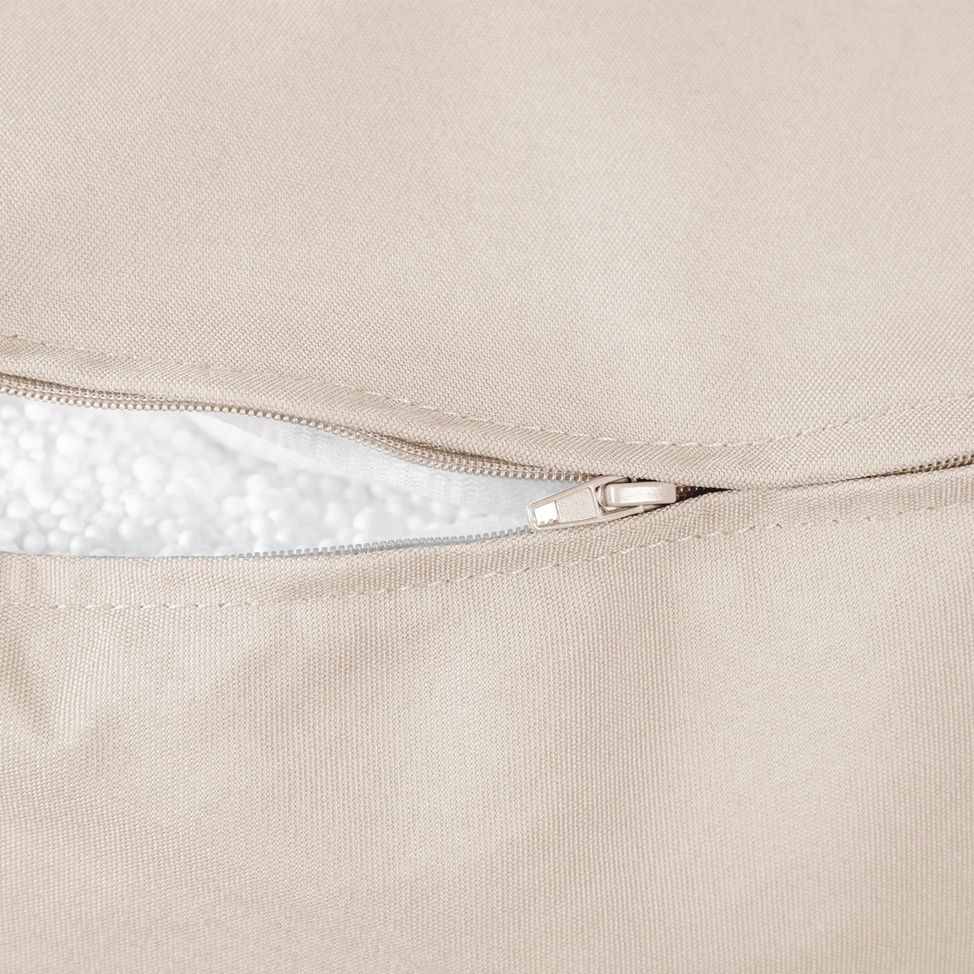 Close-up of a beige fabric with a zipper, showing texture and stitching details.