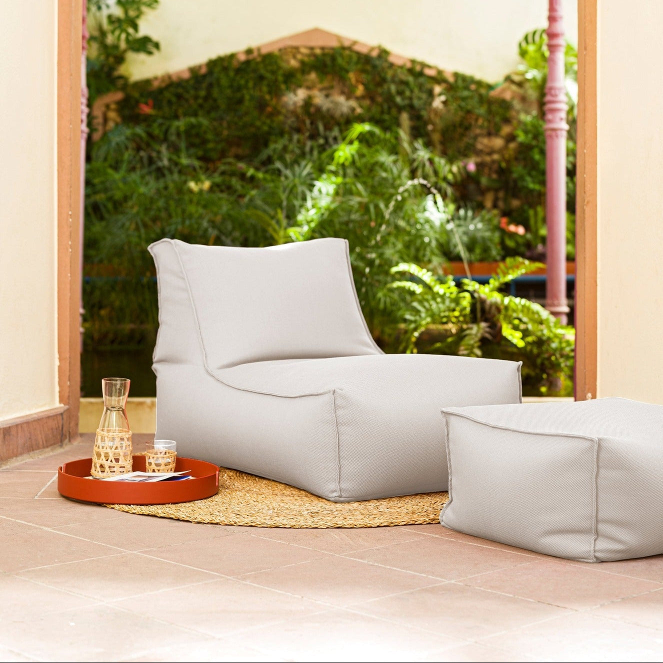 White bean bag chairs in a room with a large window showing greenery outside.