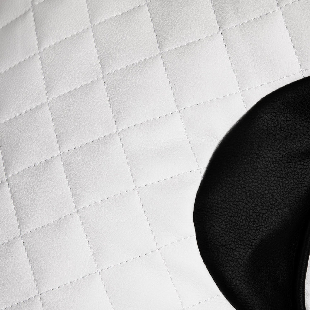 Close-up of a black object on a white quilted surface