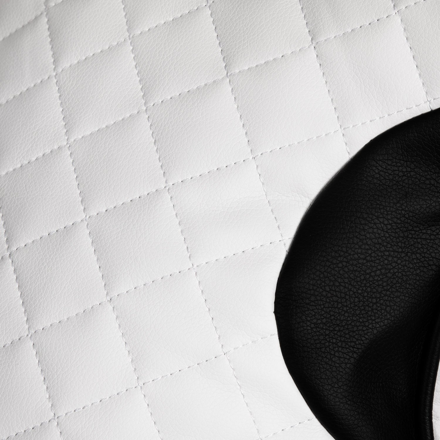 Close-up of a black object on a white quilted surface