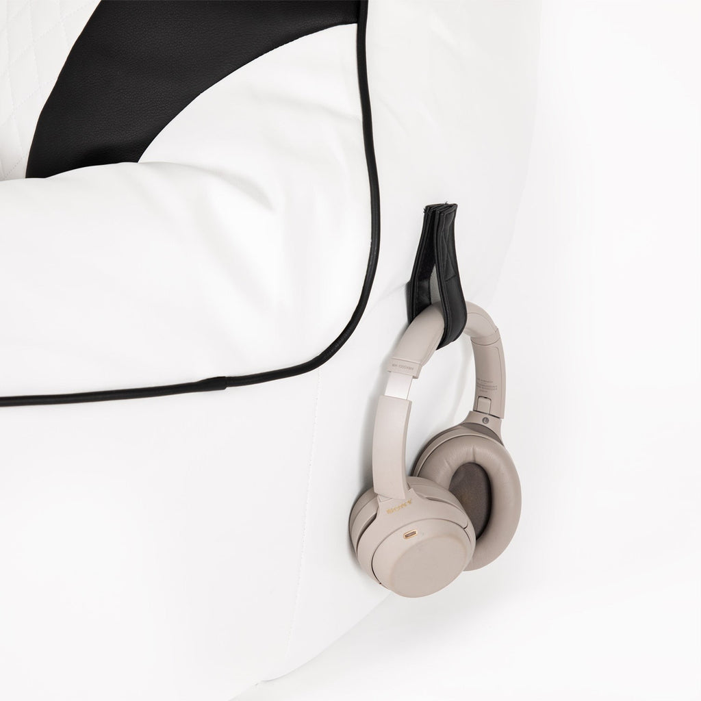 Beige headphones on a white surface with a black cord