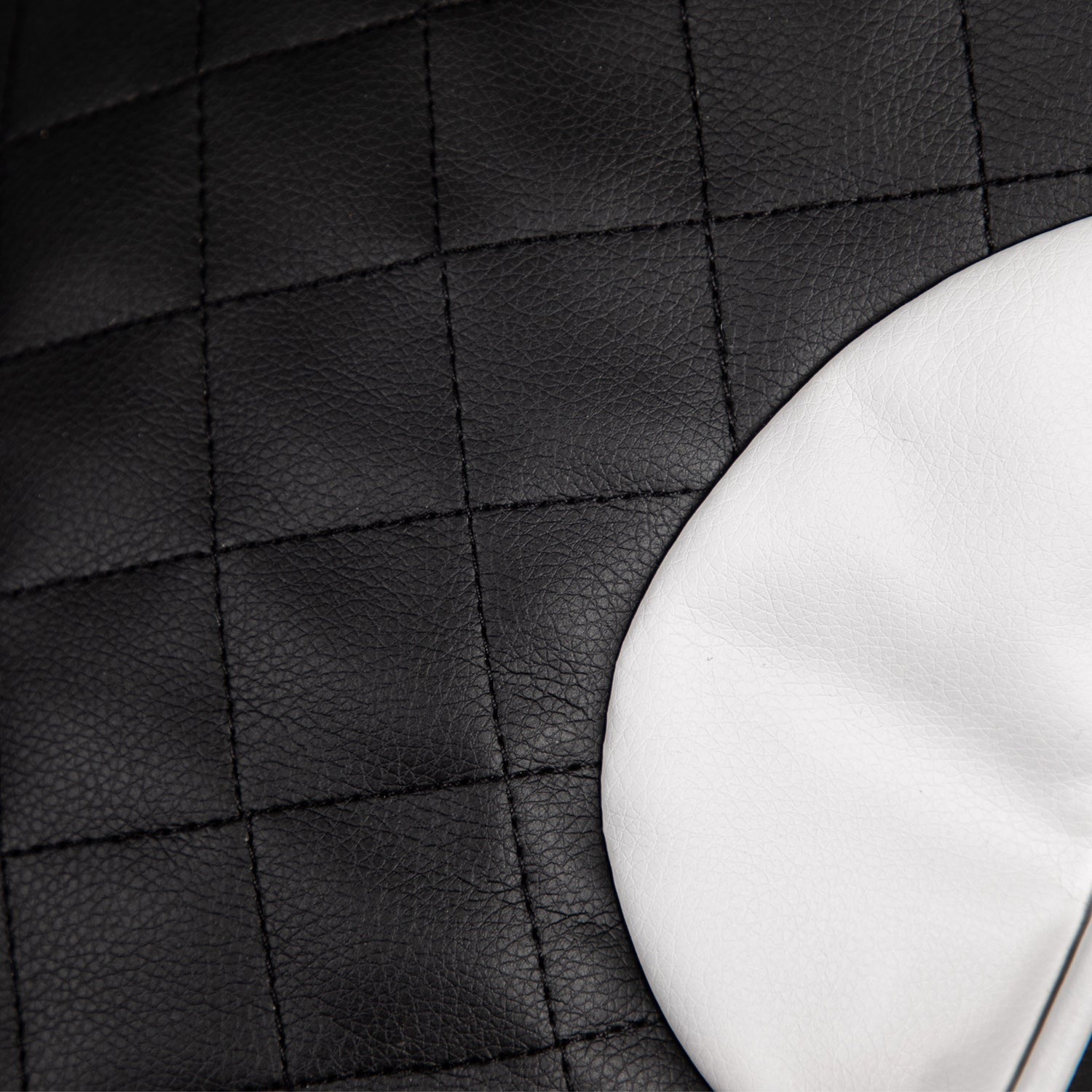 Close-up of black leather car seat with a white stitching detail