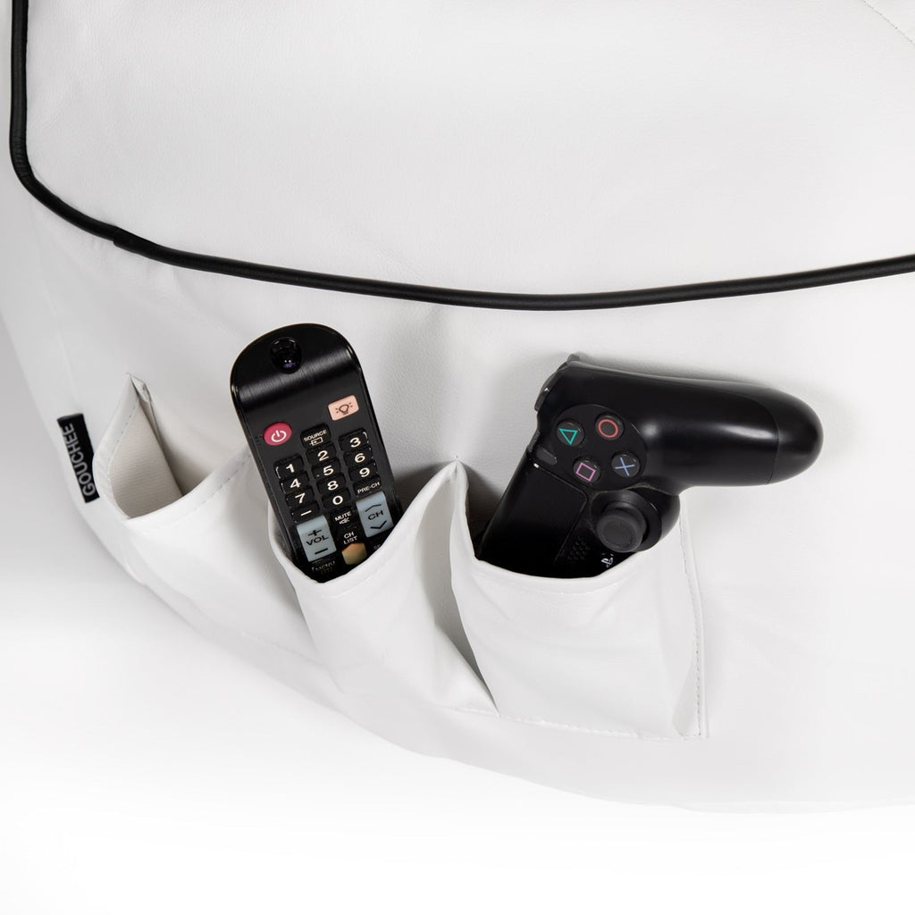Black remote control and gaming controller in a white pocket with a white background
