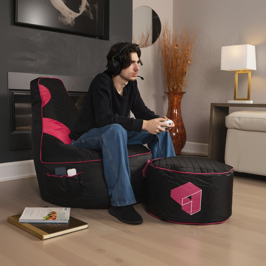 Person sitting on a black and pink bean bag chair in a living room setting.