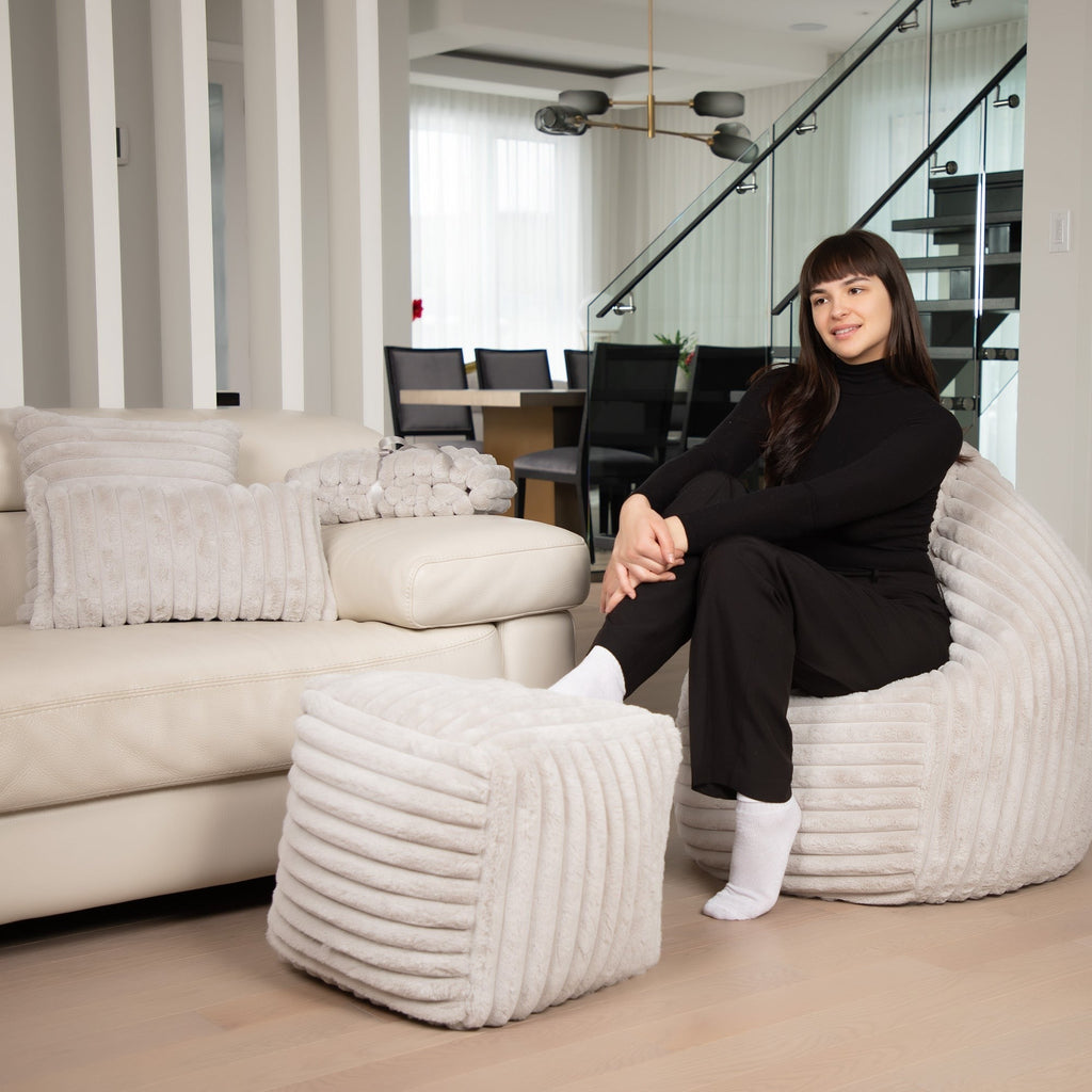 Woman sitting on a textured chair in a modern living room.