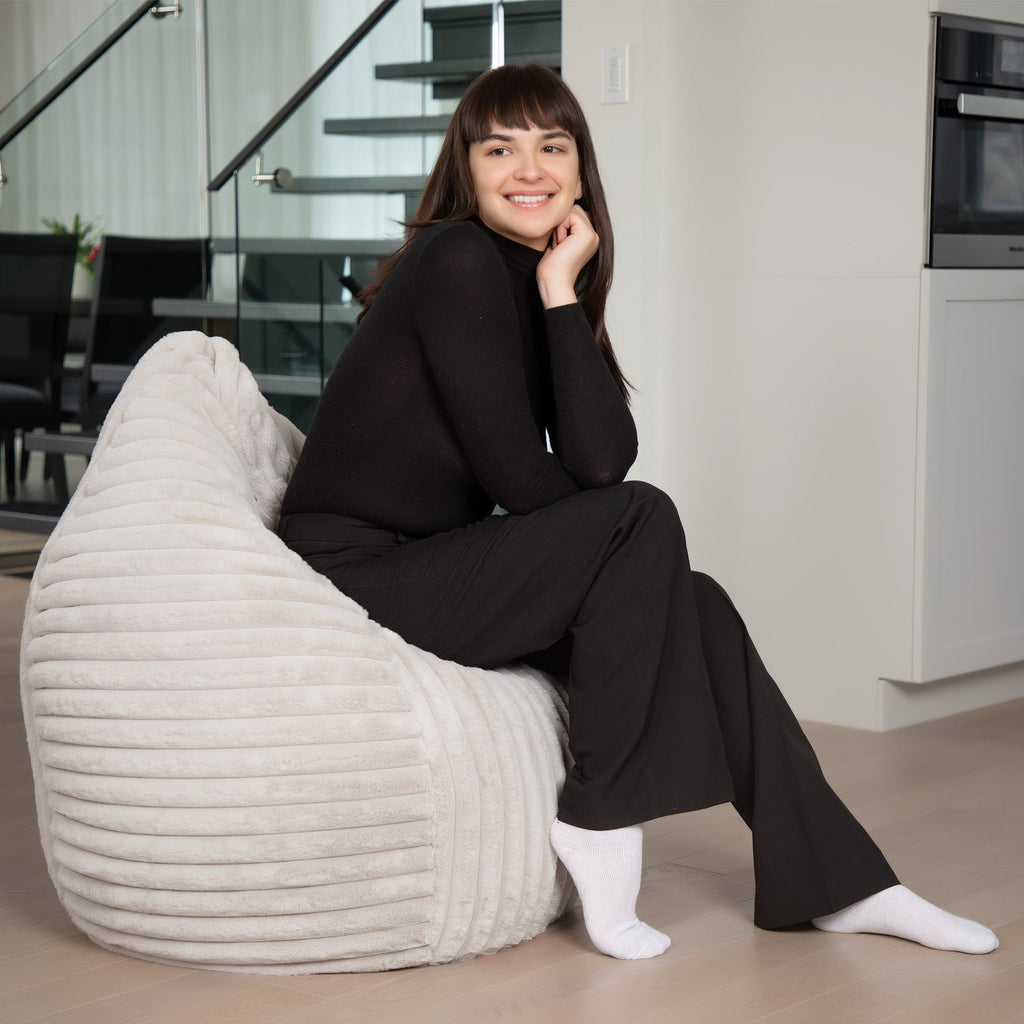 Woman sitting on a textured white chair in a modern interior setting