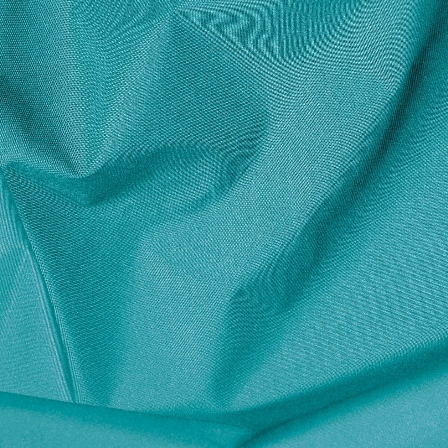 Close-up of teal fabric with folds