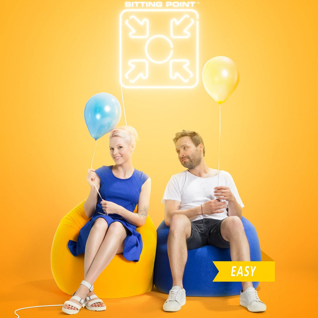 Two people sitting on colorful chairs with balloons against an orange background, featuring the brand 'Sitting Point'.