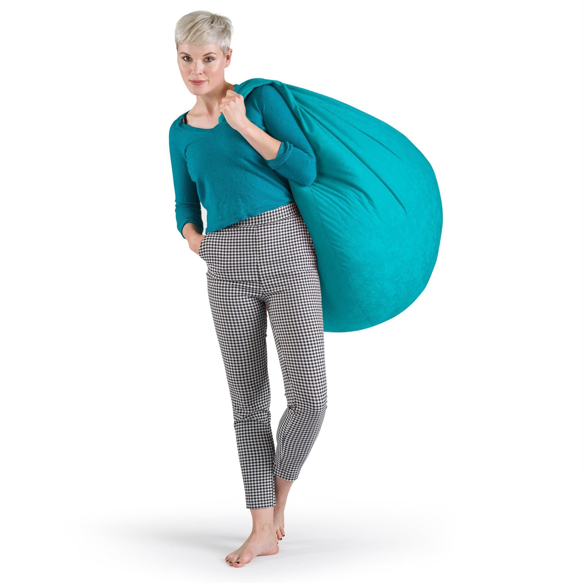 Woman holding a large turquoise bean bag against a white background