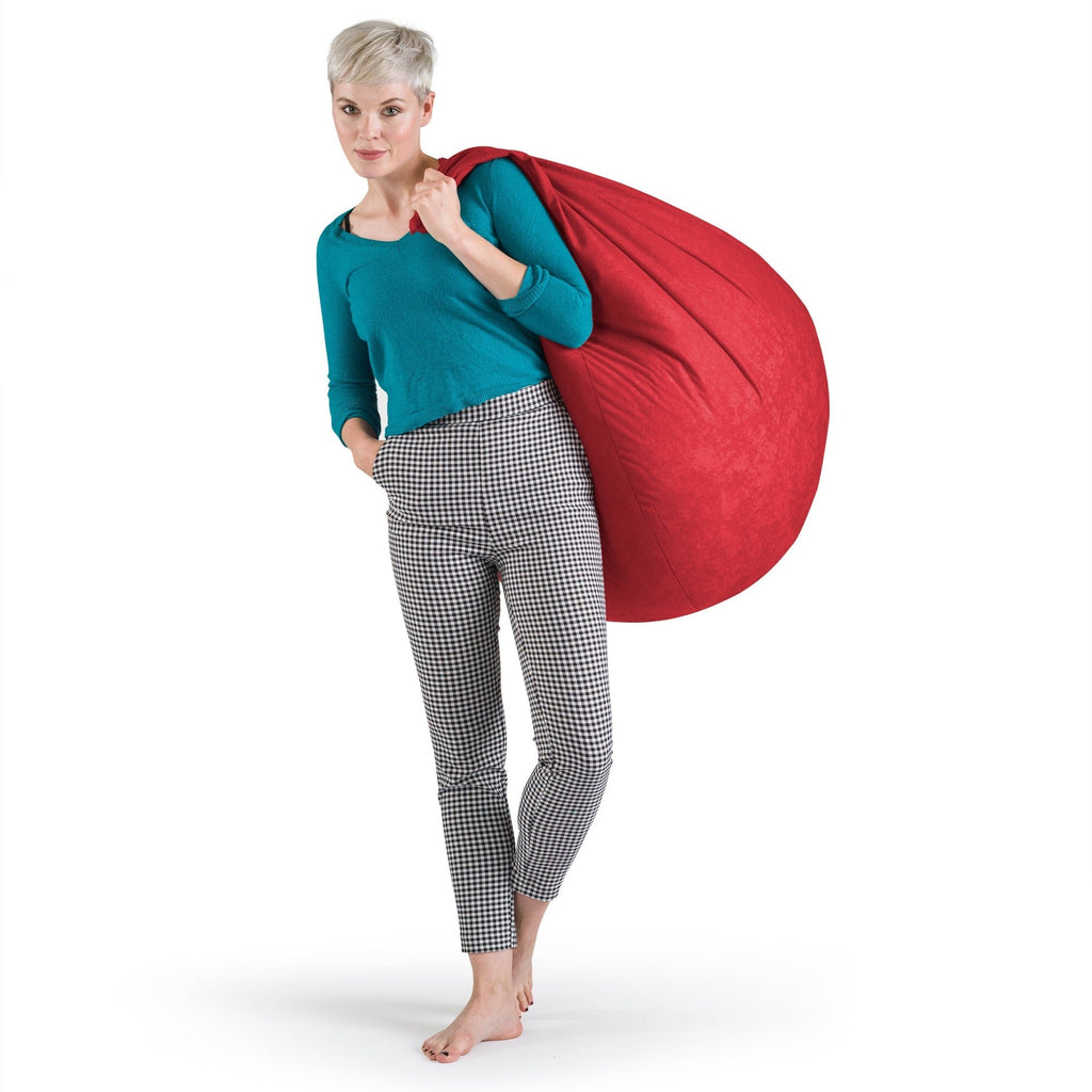 Woman holding a large red bean bag against a white background