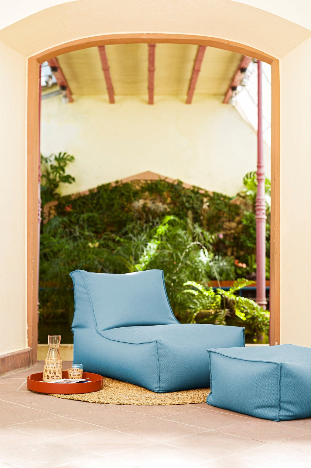 Blue bean bag chair in a room with a large window view of greenery