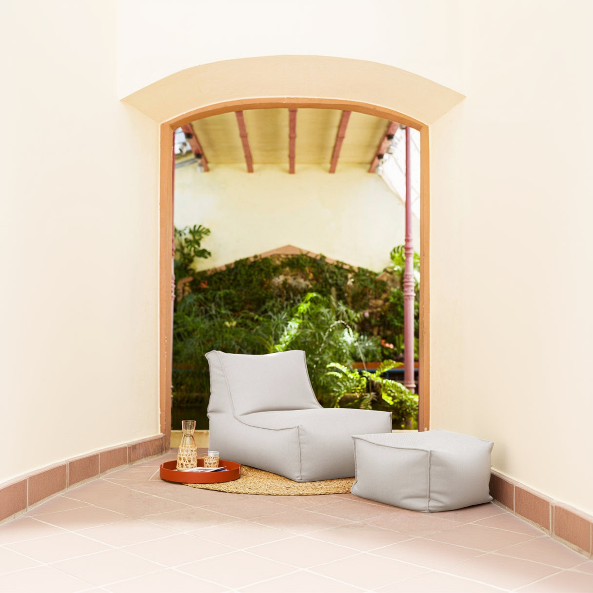 White bean bag chairs in a room with a large window showing greenery outside.