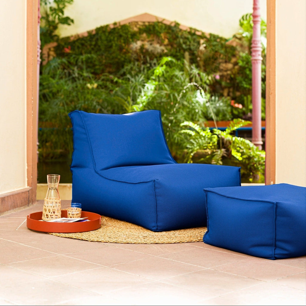 Blue bean bag chairs in a room with a large window showing greenery outside.