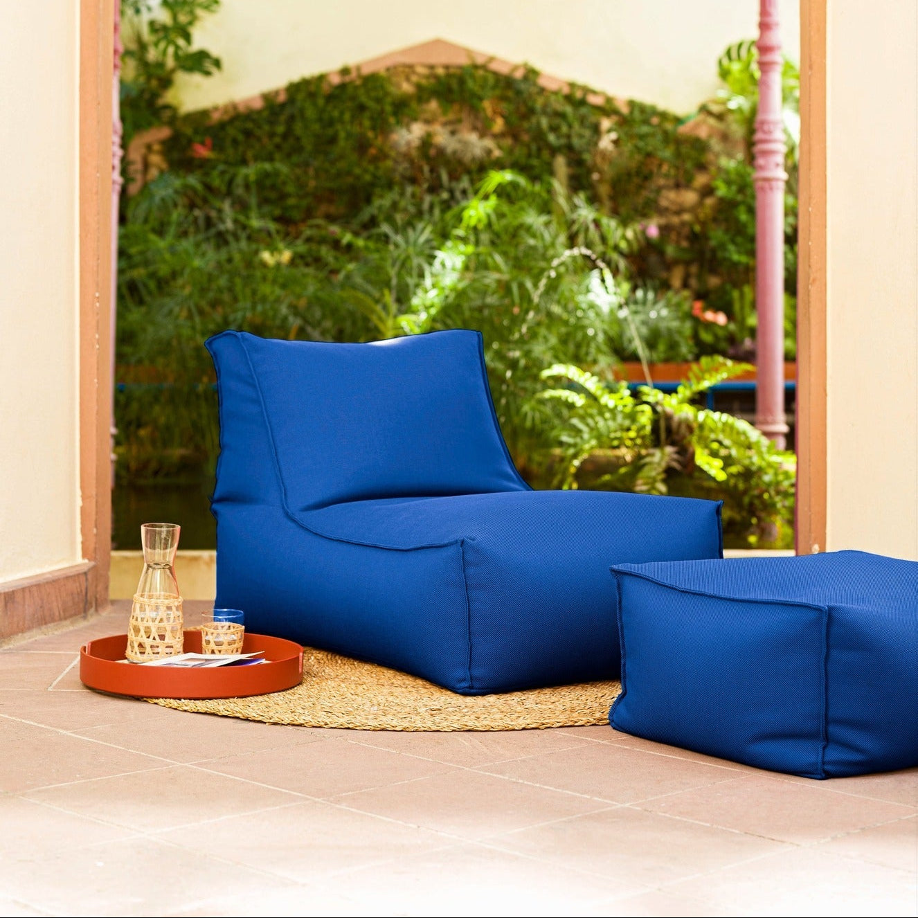 Blue bean bag chairs in a room with a large window showing greenery outside.