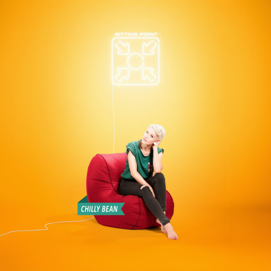 Woman sitting on a red bean bag chair with a yellow background and 'Chilly Bean' branding.
