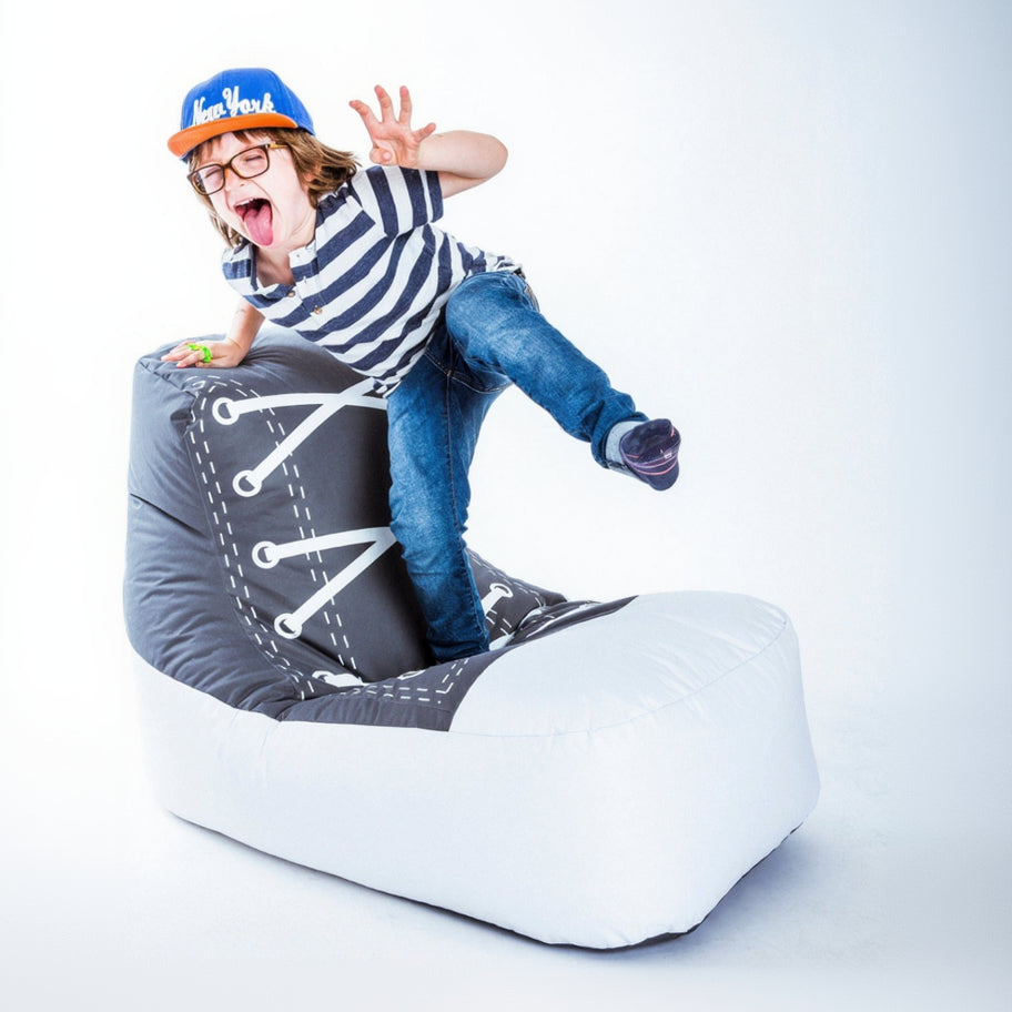 Child sitting on a large shoe with a white background