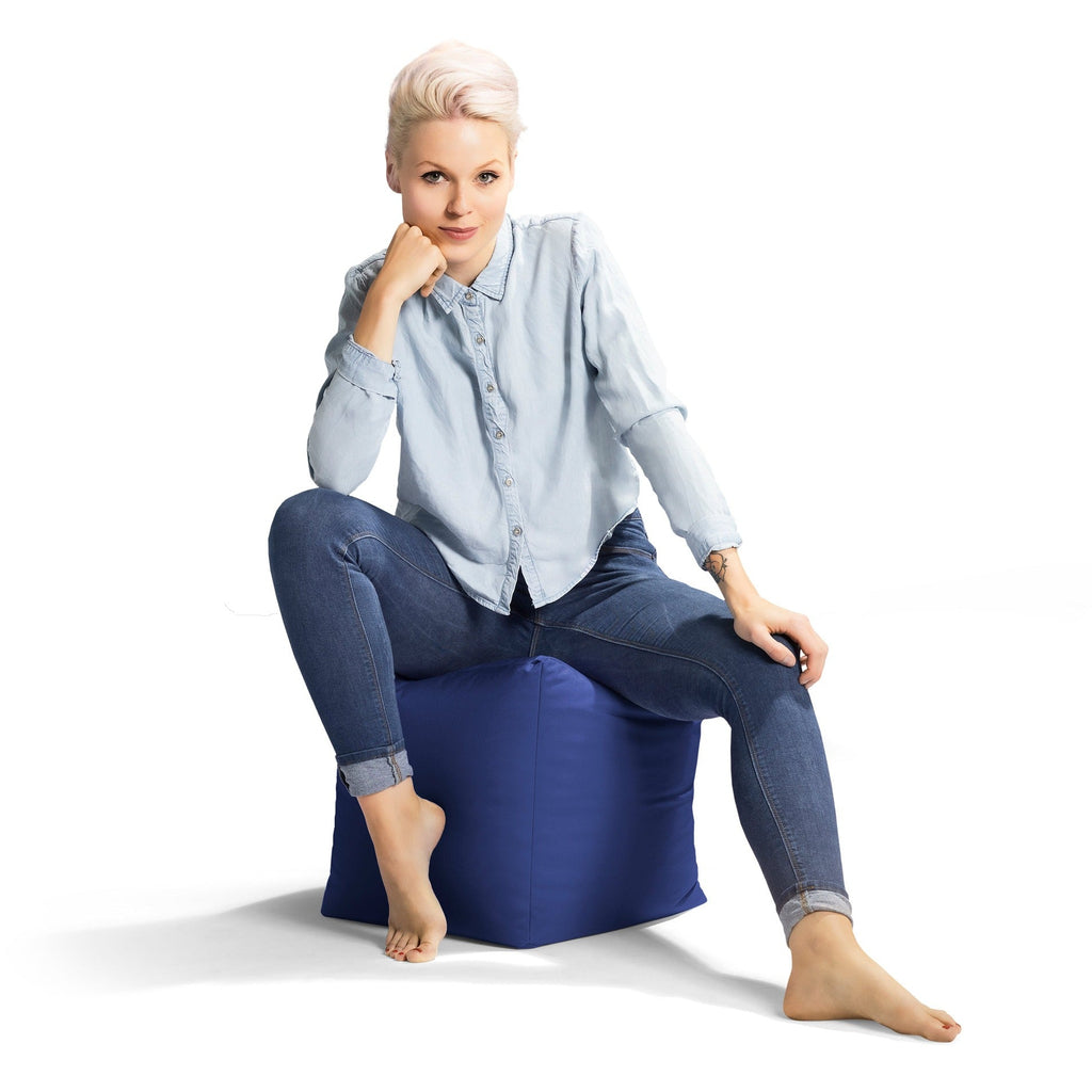 Woman sitting on a blue bean bag chair against a white background