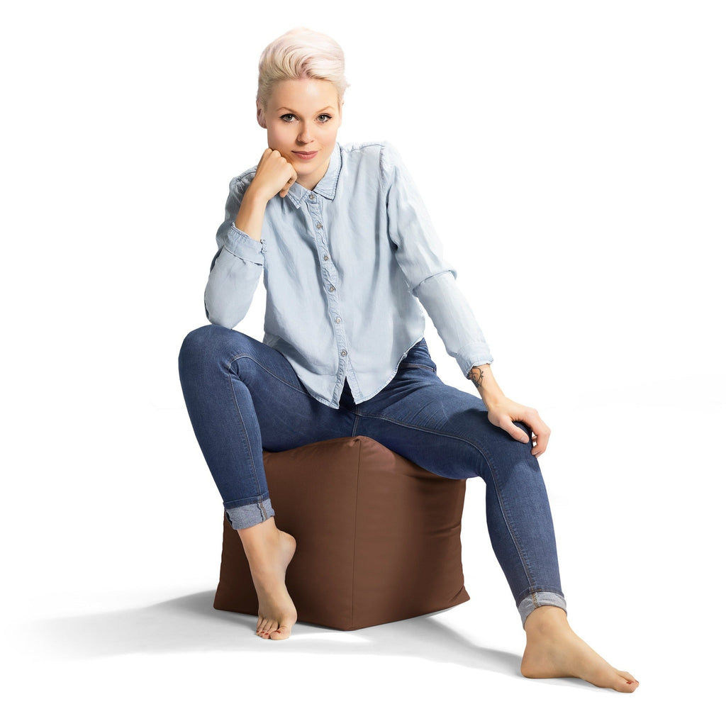 Woman sitting on a brown bean bag chair against a white background