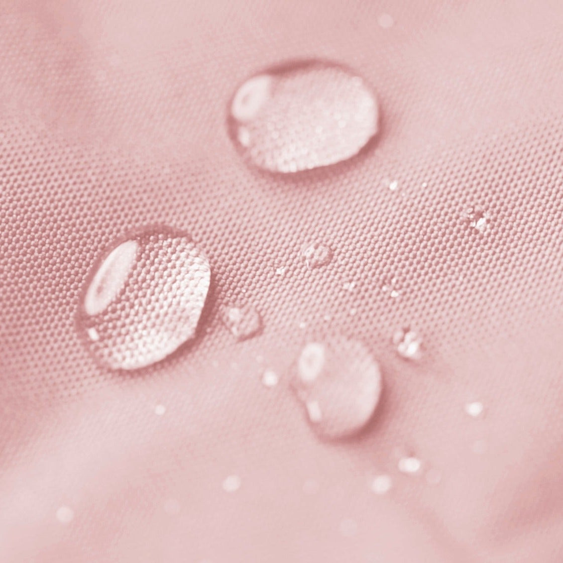 Close-up of water droplets on a pink textured surface