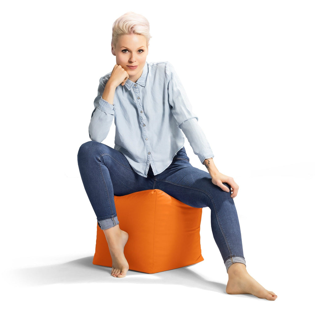 Woman sitting on an orange bean bag chair against a white background