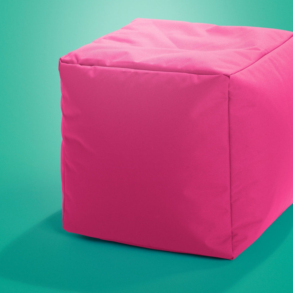 Pink cube-shaped ottoman on a teal background