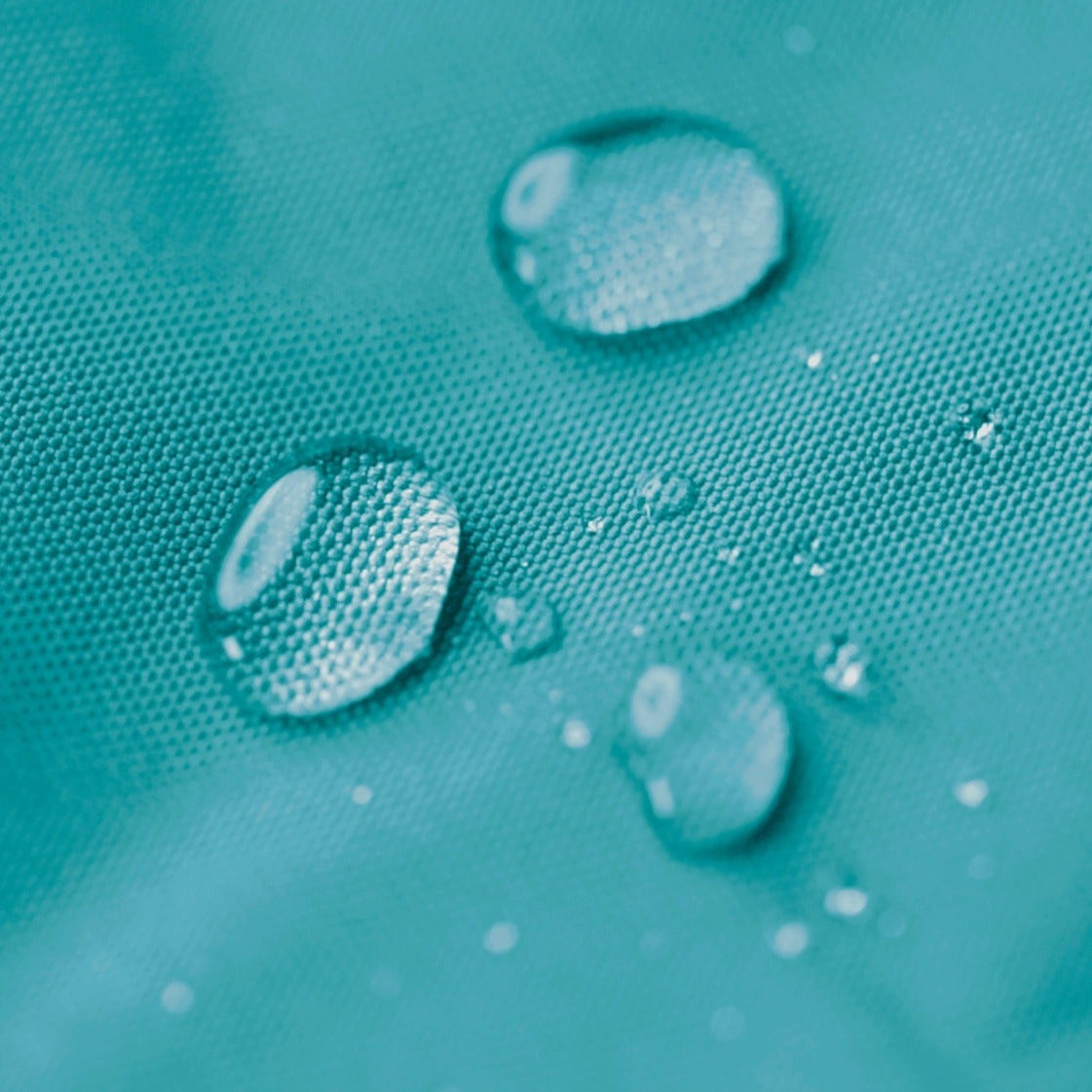 Close-up of water droplets on a textured teal surface