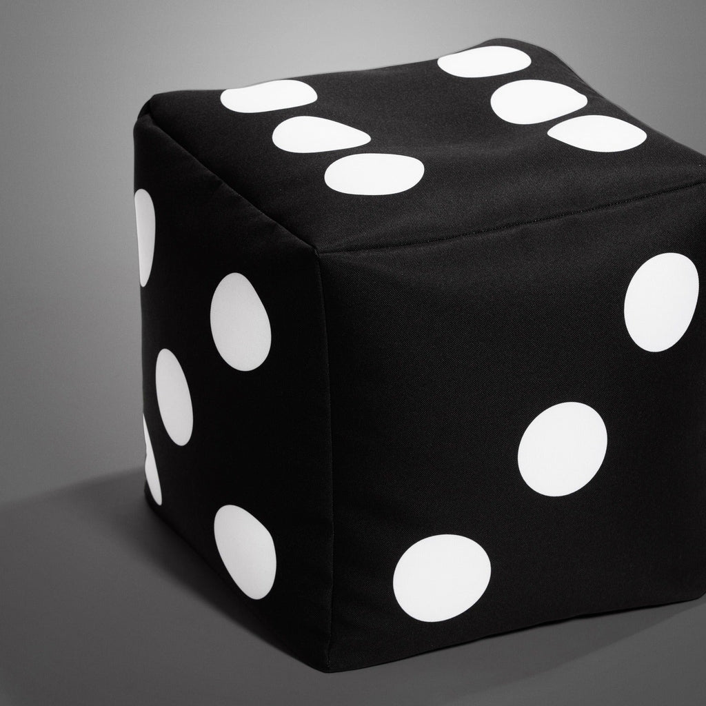 Black cube with white dots on a gray background