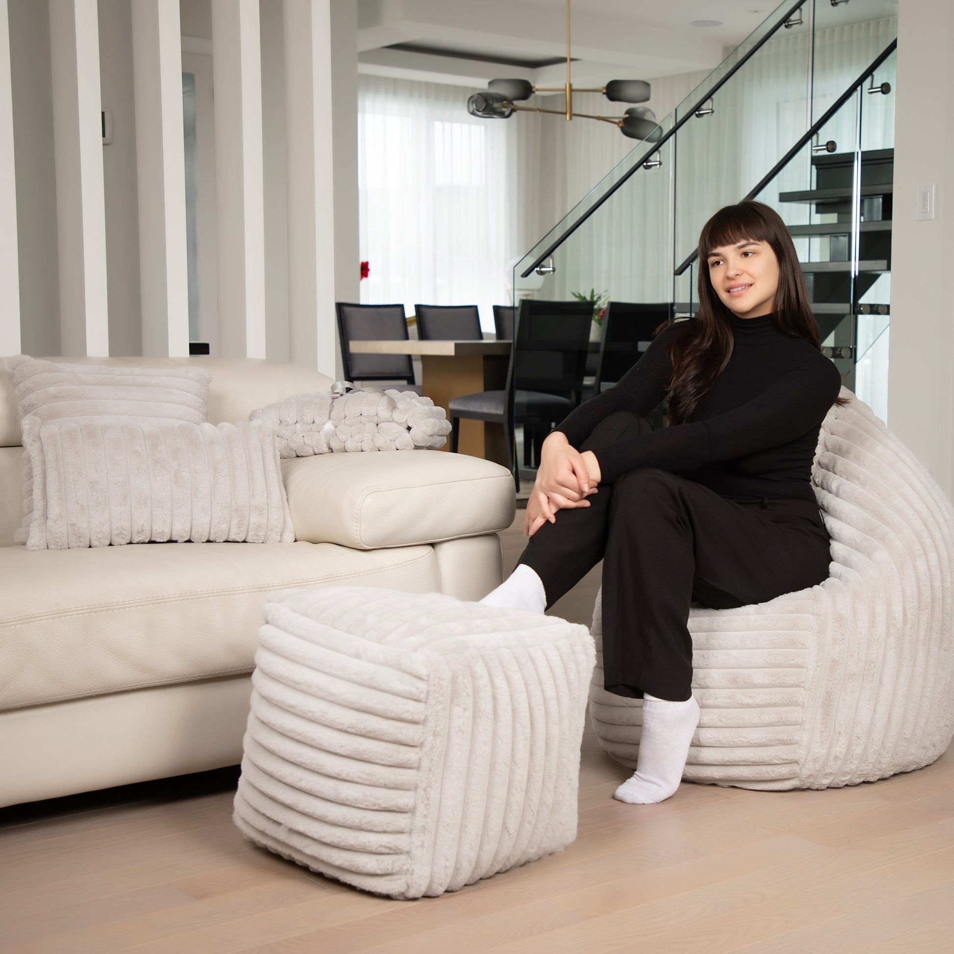 Woman sitting on a textured chair in a modern living room.