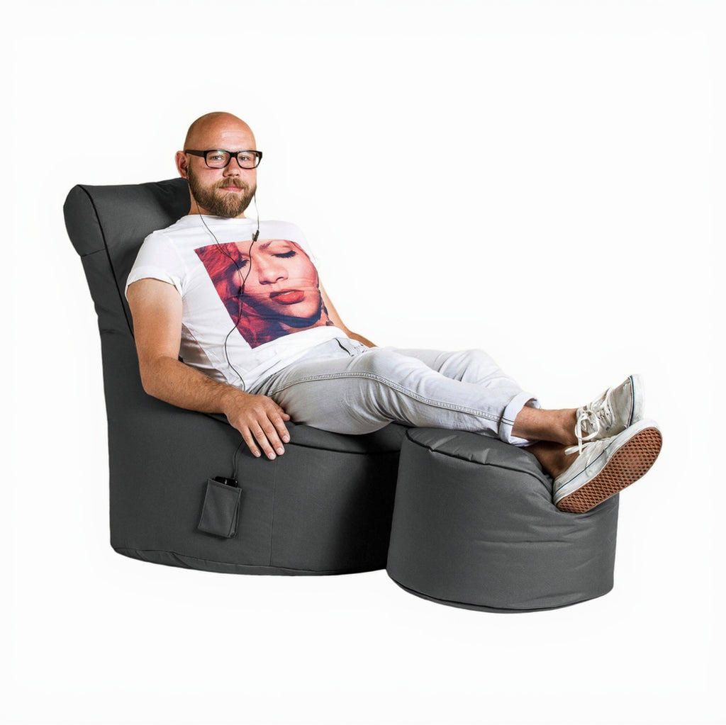 Man sitting on a gray bean bag chair with a white background