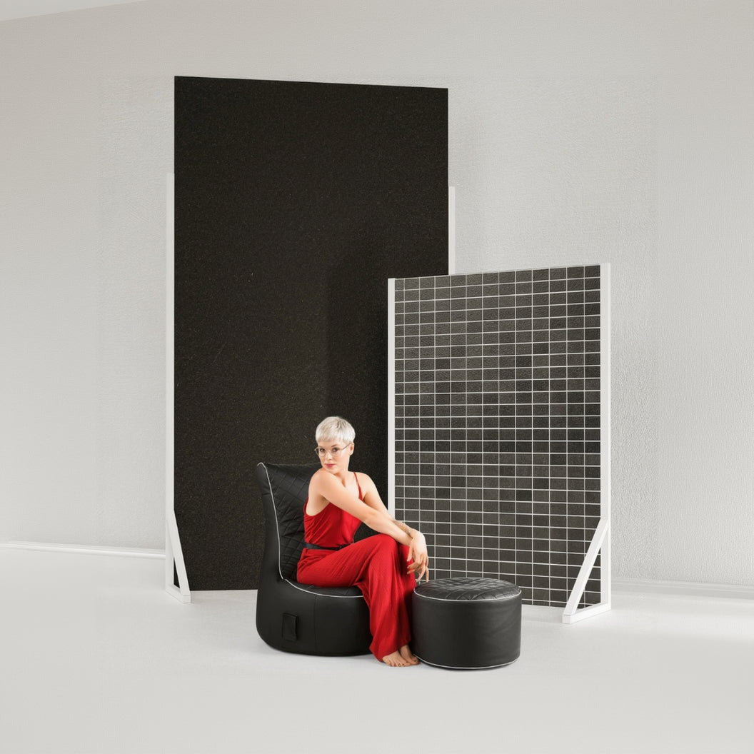 Woman in a red dress sitting on a black chair with acoustic panels in the background