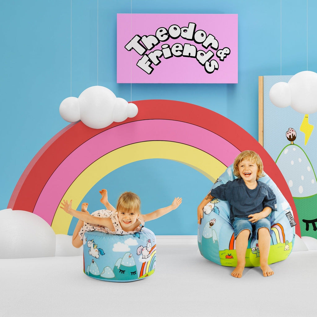 Children playing with colorful chairs shaped like a rainbow and a cloud, with 'Theodor & Friends' sign on the wall.