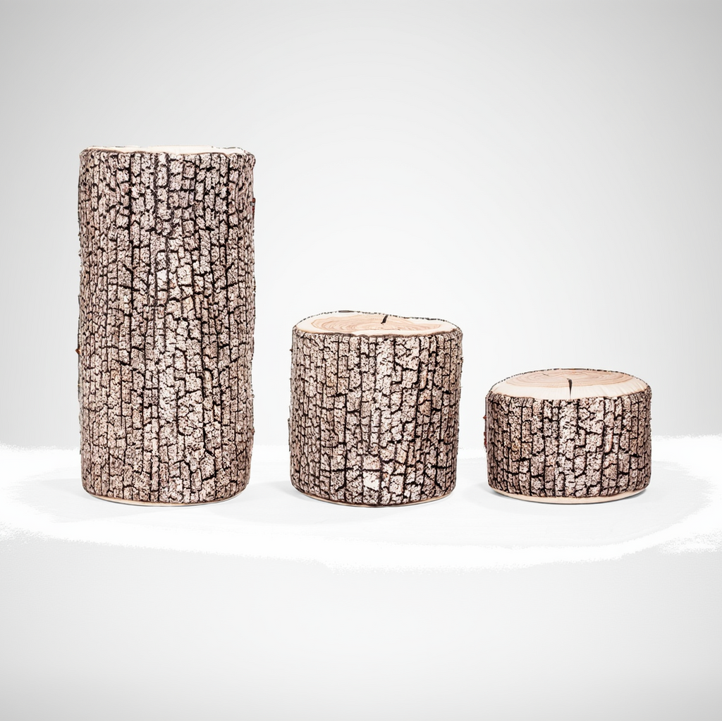 Three cylindrical candles with bark-like texture on a white background