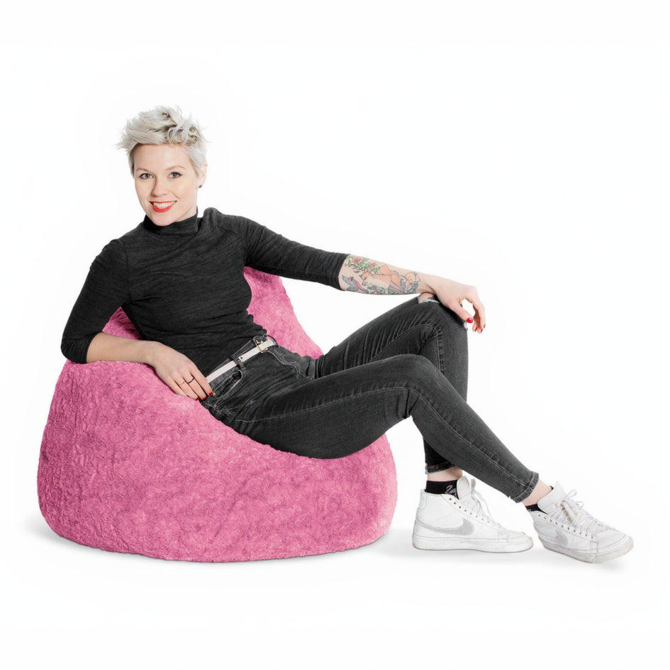 Person sitting on a pink bean bag chair against a white background