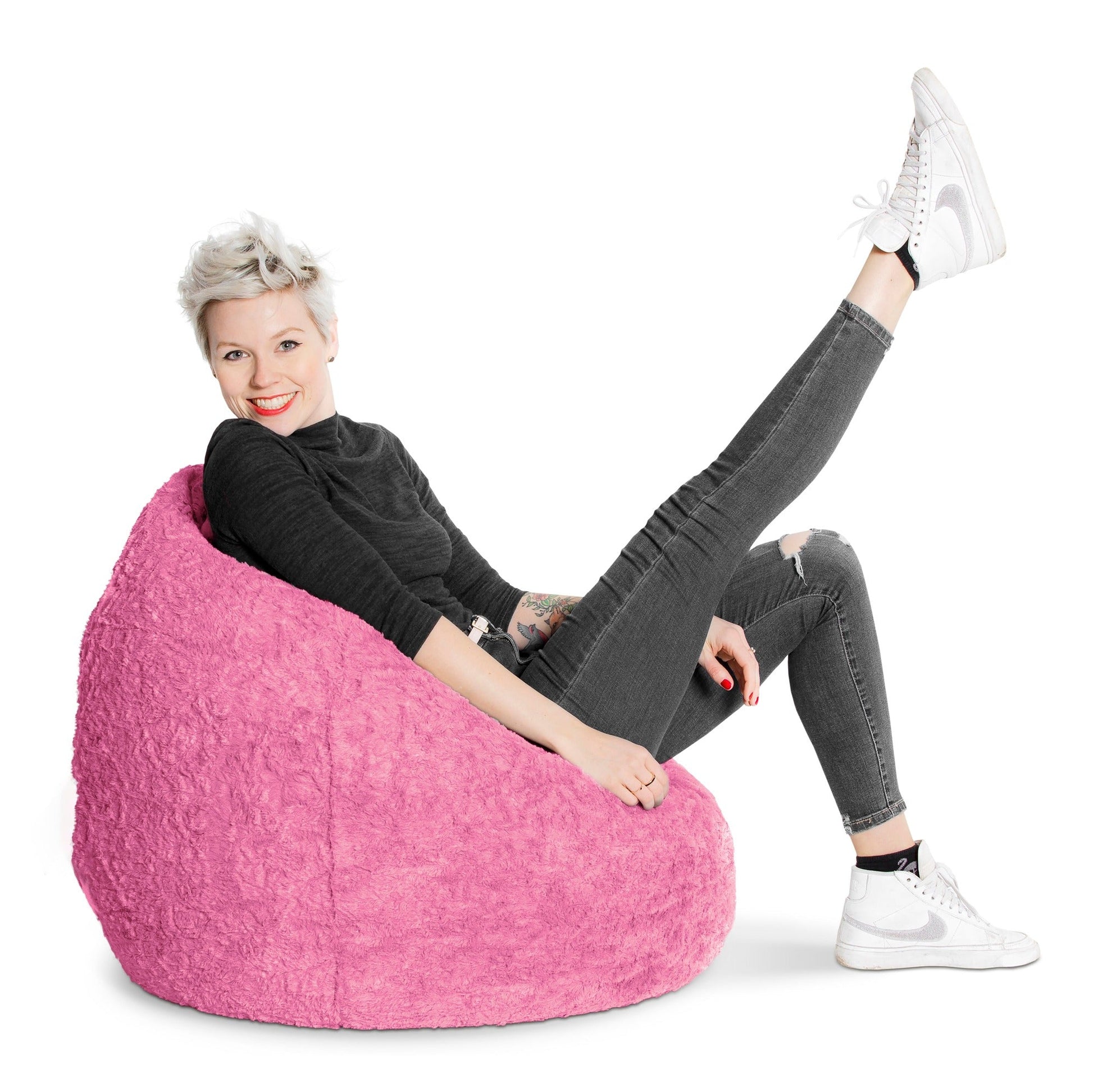 Person sitting on a pink bean bag chair with a white background