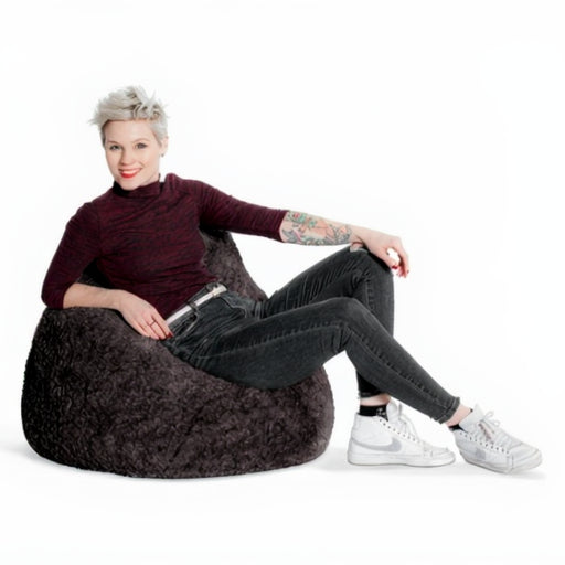 Woman sitting on a bean bag chair against a white background