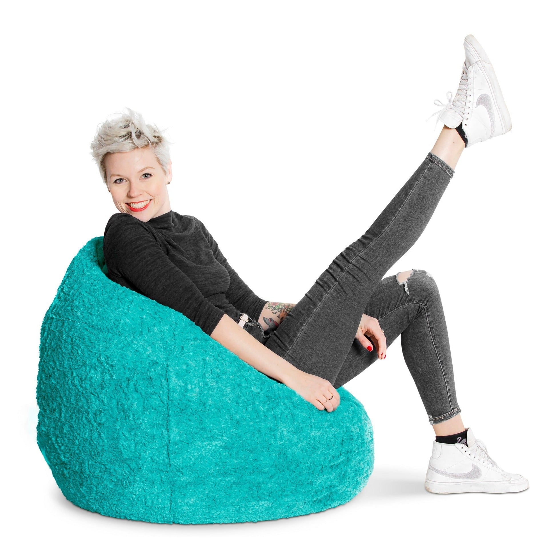 Person sitting on a teal bean bag chair with a white background