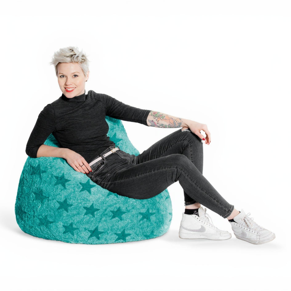 Person sitting on a teal bean bag chair against a white background