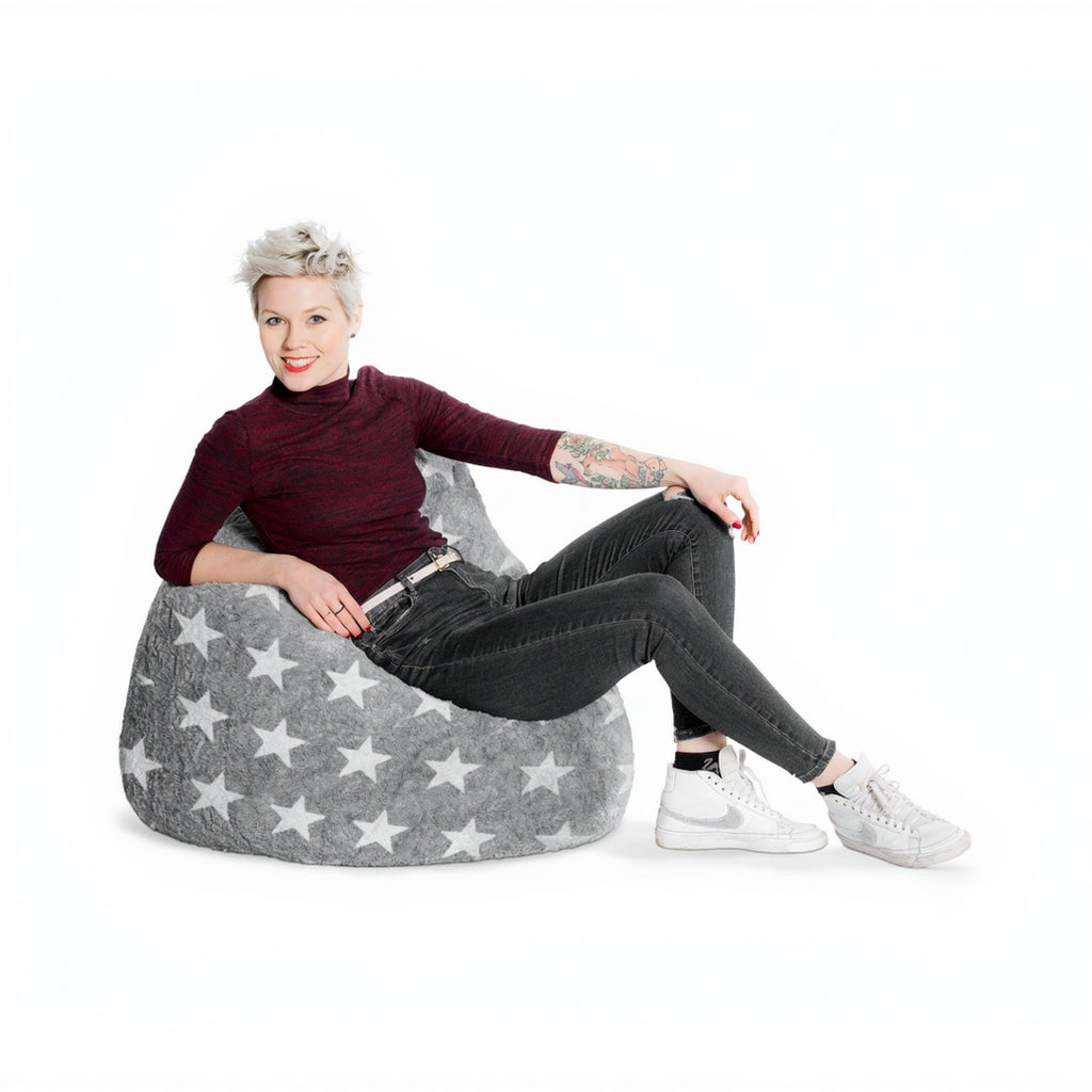 Woman sitting on a gray bean bag chair with star pattern on a white background
