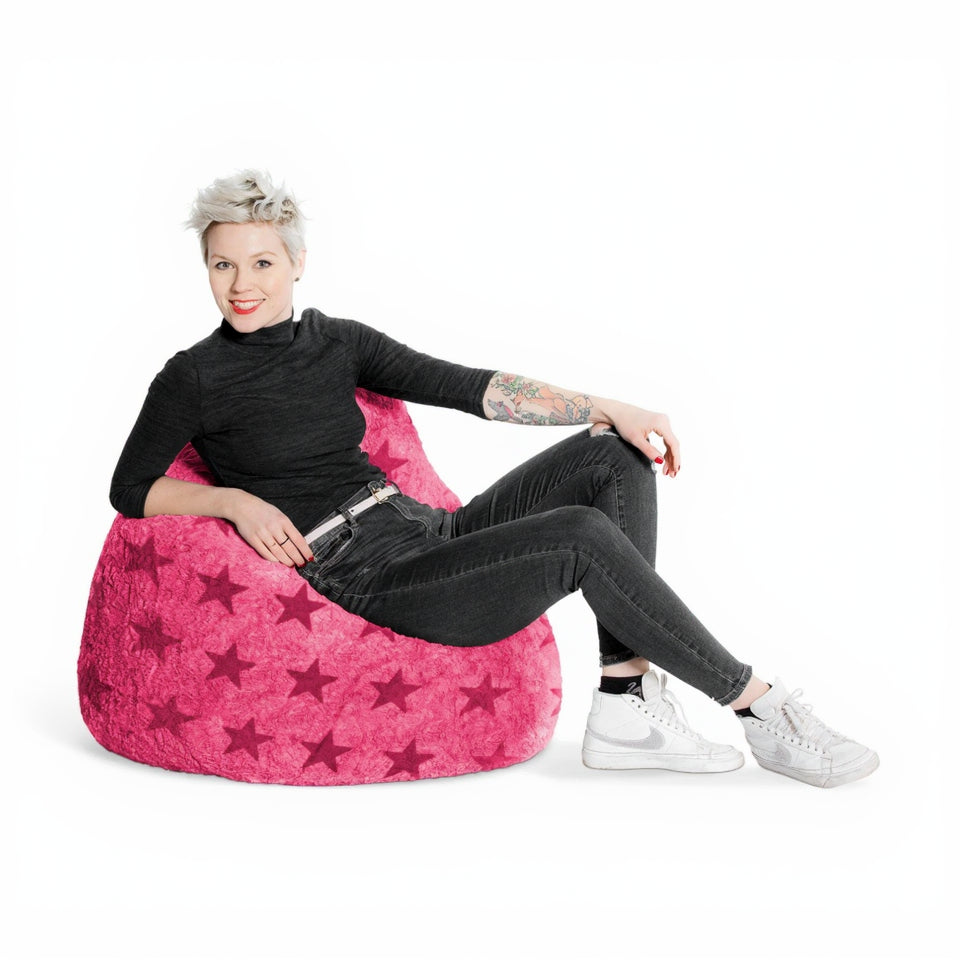 Person sitting on a pink bean bag chair with star pattern