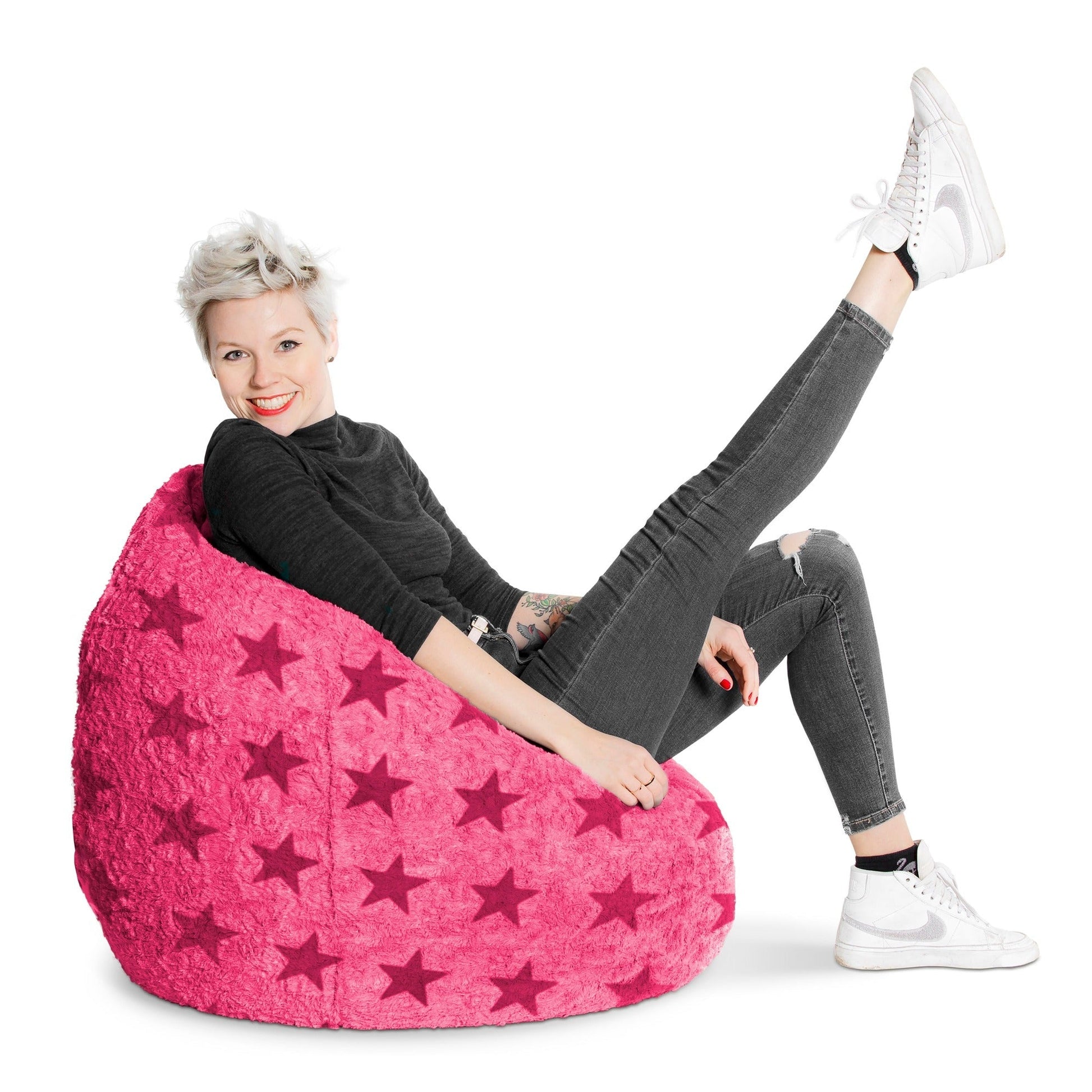 Person sitting on a pink bean bag chair with star pattern