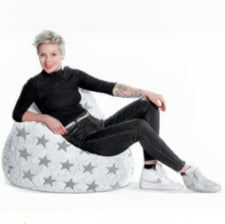 Person sitting on a star-patterned bean bag chair against a white background