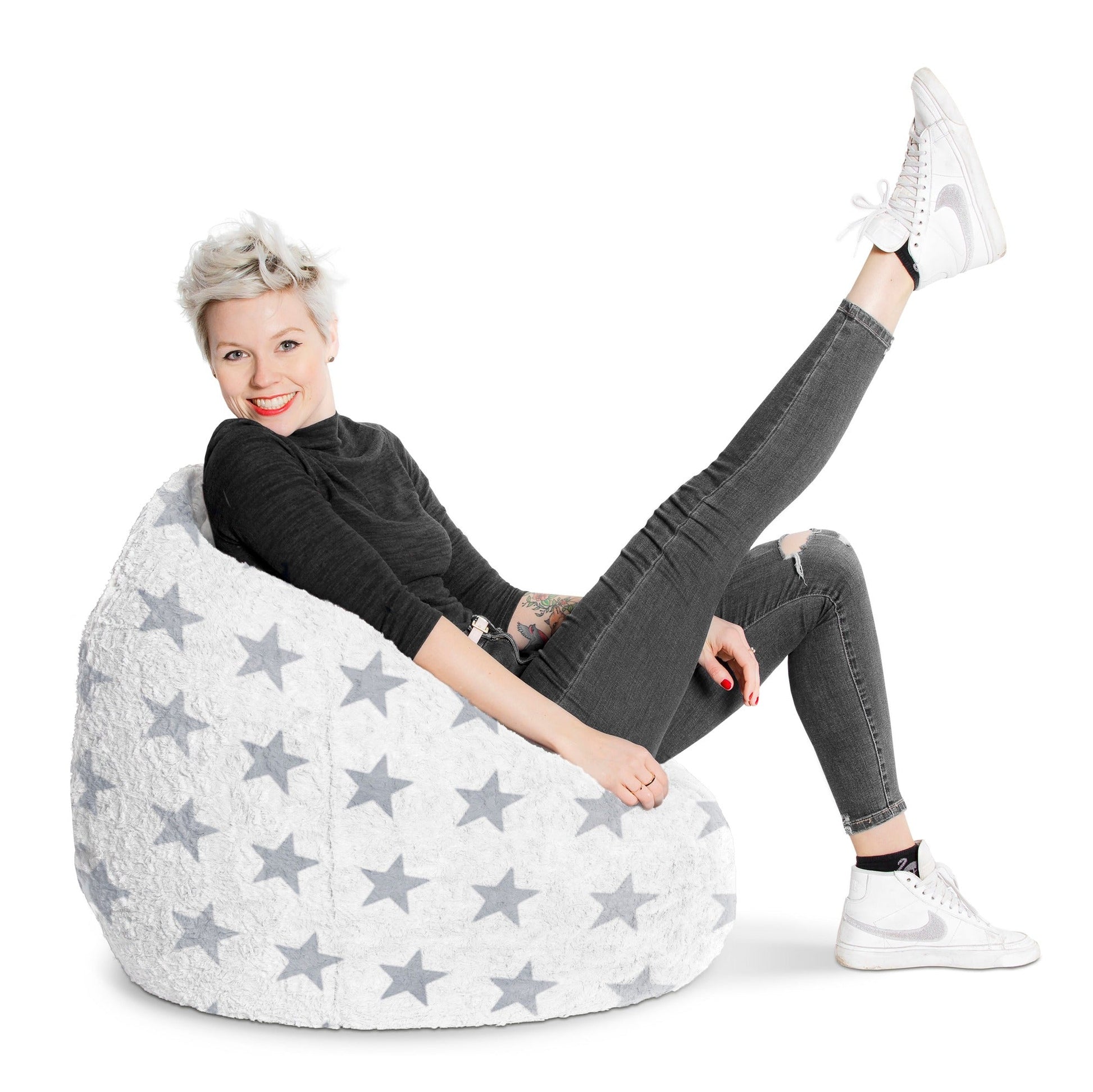 Person sitting on a star-patterned bean bag chair against a white background