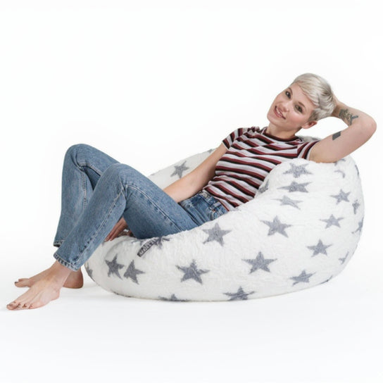 Woman sitting on a star-patterned bean bag chair against a white background