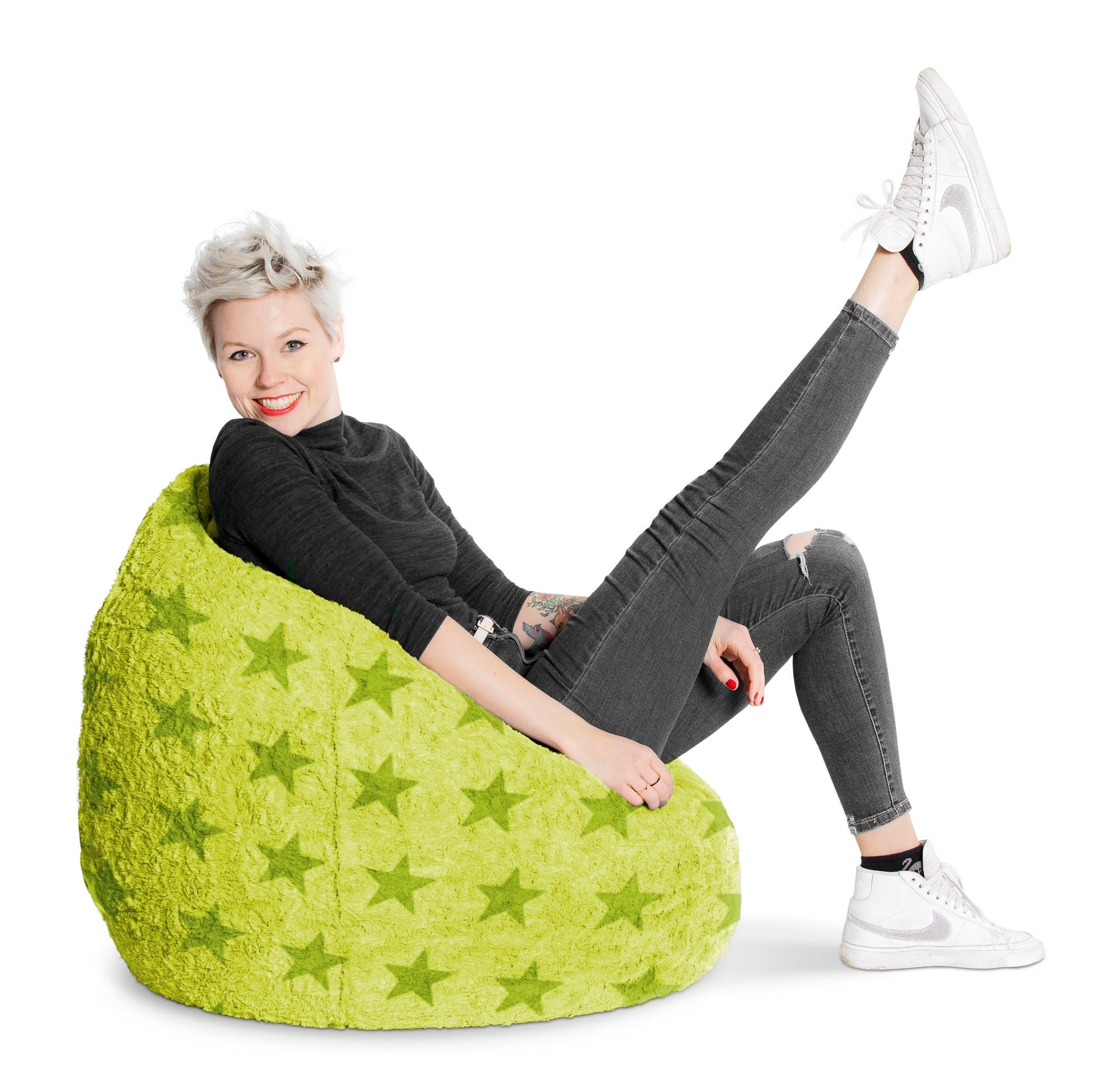 Person sitting on a green bean bag chair with star pattern on a white background