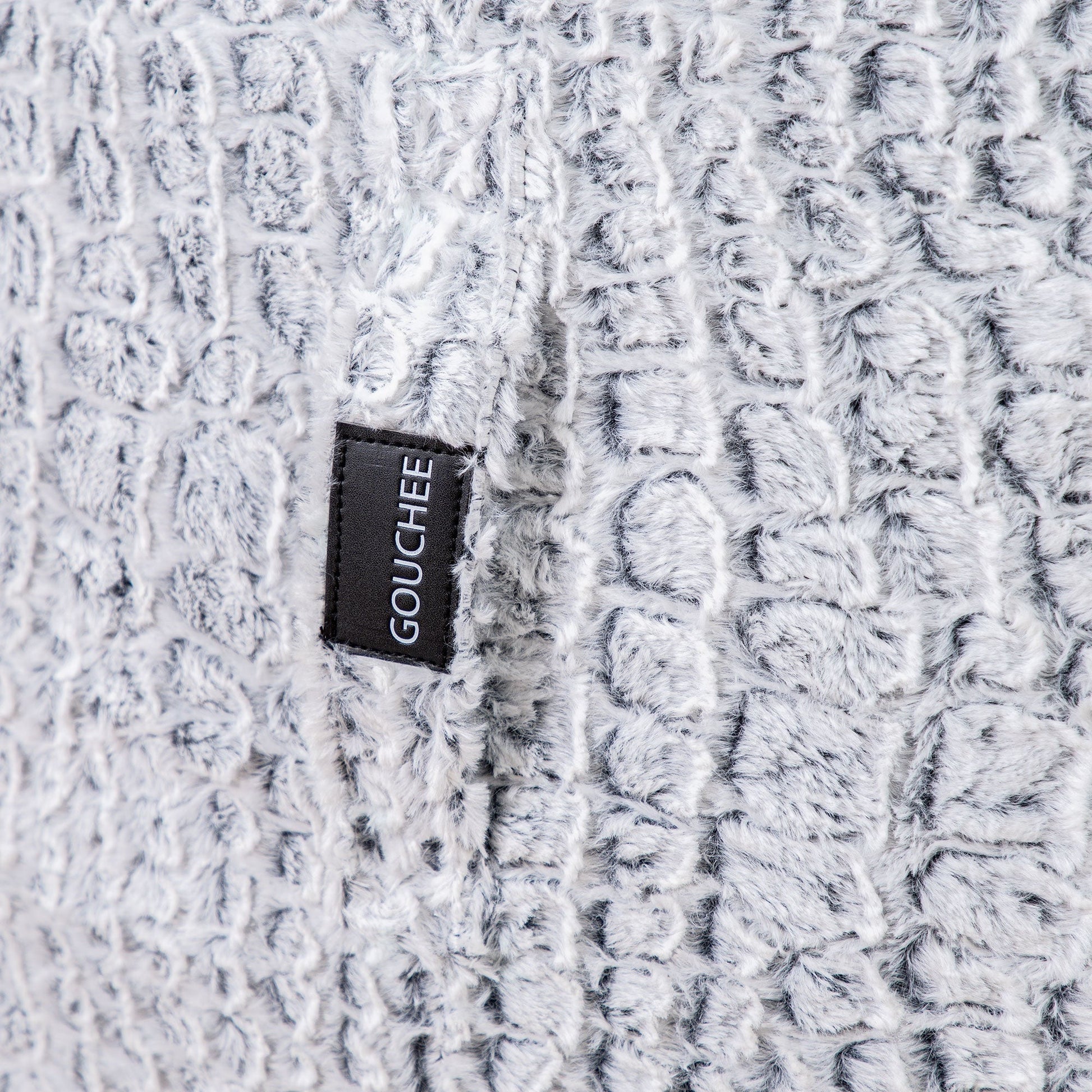 Close-up of a textured fabric with a 'Gouchée' label.