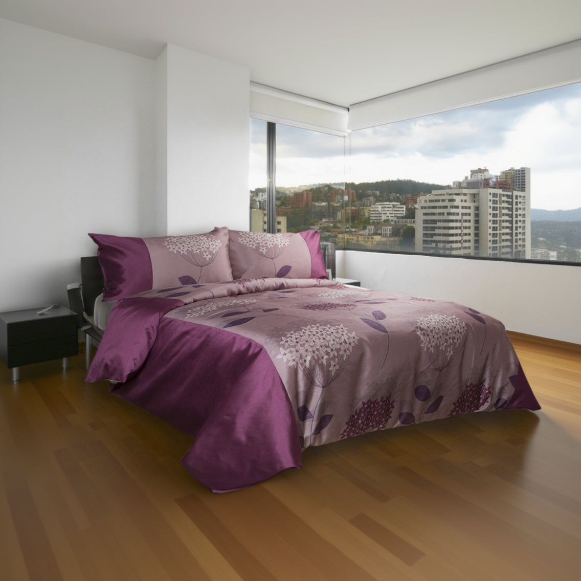 Purple and gray floral patterned bedding set on a bed in a modern bedroom with large windows.
