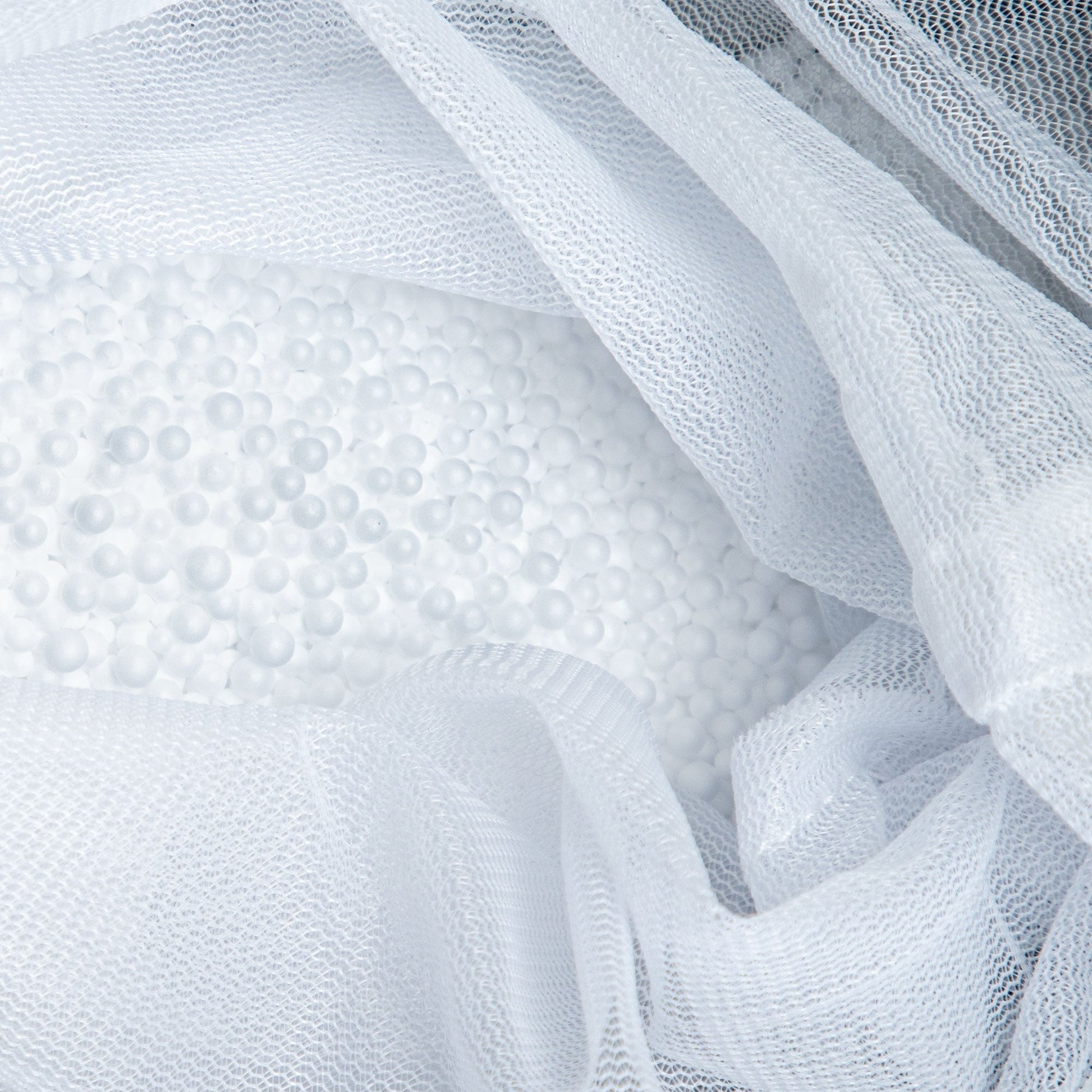 Close-up of textured white fabric with a mesh overlay